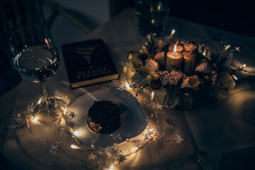 Beautiful advent wreath with candles on a festive table with Christmas lights. 