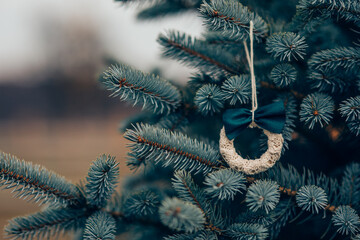 Simple small Christmas decorations on a tree outdoors in the garden. 