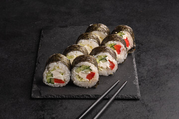 Tasty Japanese food rolls with fish and avocado on black background. Sushi menu.
