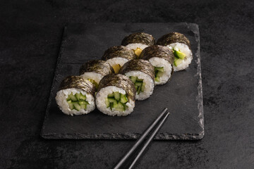 Tasty Japanese food rolls with fish and avocado on black background. Sushi menu.