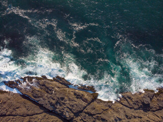 Aerial view Seething turquoise sea water with foamy waves and rocky shore. Beautiful landscape. There are no people in the photo. Ecology, environmental protection, geology. © Anton