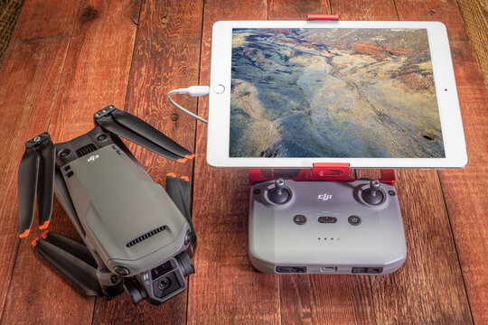 Fort Collins, CO, USA - November 21, 2021: Mavic 3 - the newest foldable consumer drone from DJI on a rustic picnic table with the radio controller and ipad tablet displaying aerial image of prairie