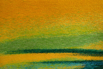Abstraktes Muster von einem farbigen Stoff mit gestickten groben Wollfäden in Nahaufnahme