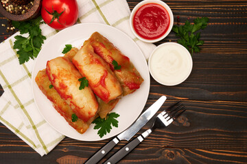 Portion of stuffed cabbage rolls on wooden table