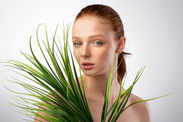 Fototapeta premium Headshot Of Young Lady Posing With Green Plant In Studio