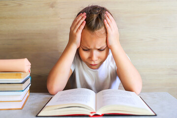 Schoolgirl girl reads books after school to know a lot