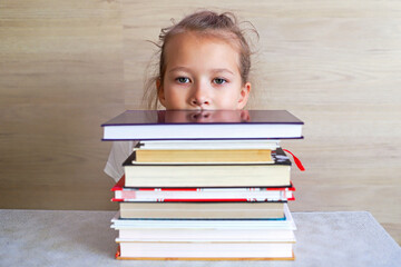 Schoolgirl girl reads books after school to know a lot