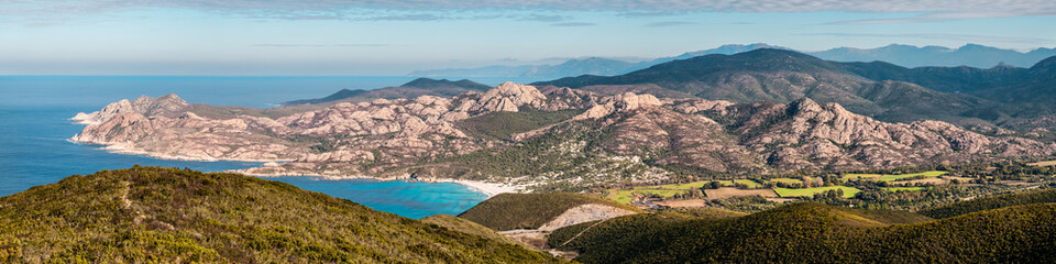Fototapeta na wymiar Panoramic view over Ostriconi beach and the turquoise Mediterranean sea in the Balagne region of Corsica with the Desert des Agriates in the distance
