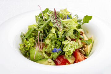 Salad with avocado and pine nuts. Isolated on a white background.