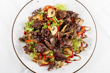 Salad with chicken liver, sweet pepper and champignons. Isolated on a white background.