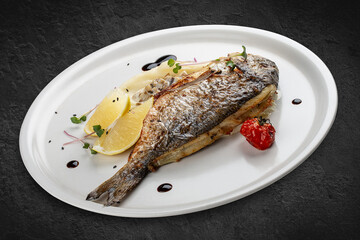 Dorado with mashed potatoes and creamy mushroom sauce. Isolated on a black background.