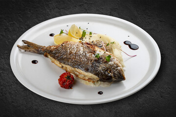 Dorado with mashed potatoes and creamy mushroom sauce. Isolated on a black background.