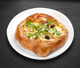 Traditional Georgian cuisine. Adjarian khachapuri. Isolated on a black background.