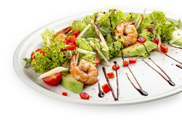 Salad with avocado and tiger prawns, seasoned with pesto sauce. Isolated on a white background.
