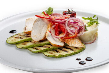Baked chicken fillet on a pillow of mashed potatoes. Isolated on a white background.