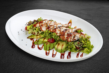 Salad with eel and avocado . Isolated on a black background.