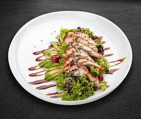 Salad with eel and avocado . Isolated on a black background.
