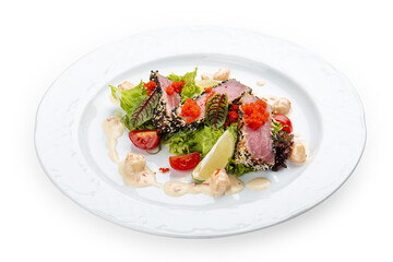 Tuna on a pillow of chuka with shrimp sauce . Isolated on a black background.