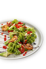 Salad with avocado and tiger prawns, seasoned with pesto sauce. Isolated on a white background.
