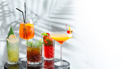 set cocktails on marble table and light background banner. five kinds of colorful summer cocktails in glasses and shadow of tropic branch on background. Mojito, Aperol Spritz, margarita