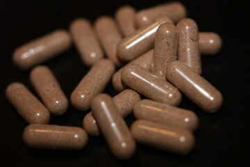 Transparent capsules filled with brown vitamins powder close up background high quality big size prints