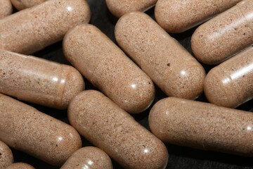 Transparent capsules filled with brown vitamins powder close up background high quality big size prints