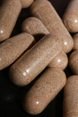 Transparent capsules filled with brown vitamins powder close up background high quality big size prints