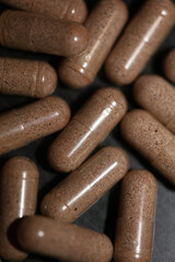 Transparent capsules filled with brown vitamins powder close up background high quality big size prints