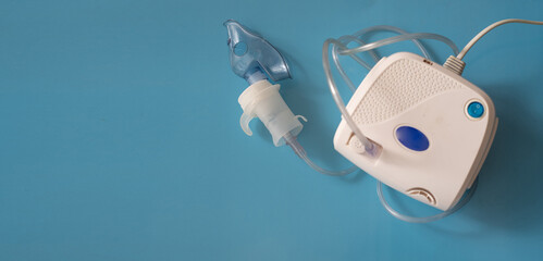 Portable breathing machine on blue background using at home. Breathing device for asthma and...