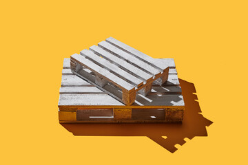 Wooden pallets on yellow pastel background