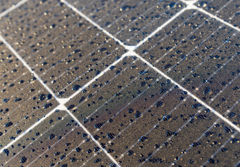 Solar panels on a construction site with raindrops on them