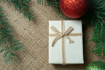 Christmas holidays composition with white gift box with and a coniferous tree branch. Happy New Year and Merry Christmas concept