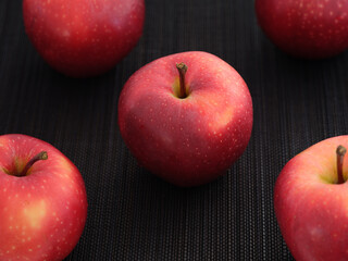 Ripe organic red apples on a black mat
