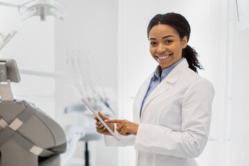 Stomatological Services. Portrait of black female dentist with digital tablet in hands