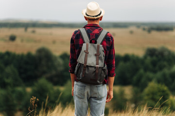 Hiker with a backpack enjoying the view of the valley, the tourist walks along the valley. Travel and adventure concept