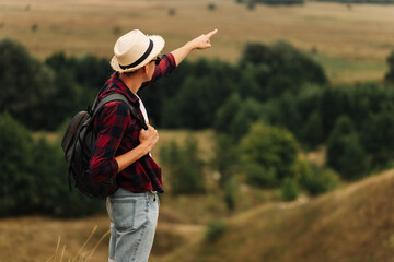 man with a backpack on a country walk on a summer day. Young people hiking in the countryside, outdoors at sunset