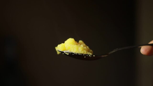 Hot corn porridge in a tablespoon. 