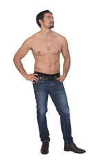 Fototapeta premium man shirtless and with blue jeans looking side on white background