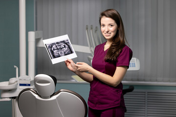 Beautiful woman doctor with dental scans in hands in a dental clinic