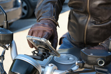 Close up of a person using mobile phone on motorbike