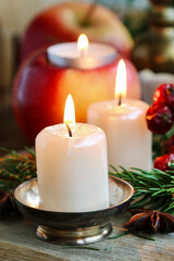 Beautiful candles and other traditional Christmas decorations on the table.
