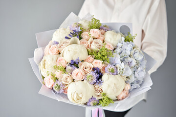 Wonderful bouquet of mixed flowers in woman hand. Handsome fresh bouquet. Small flower shop and Flowers delivery.