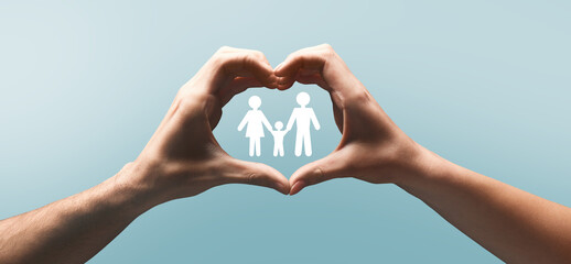 Hands of european man and lady make heart gesture with silhouette of mom, dad and kid between arms