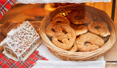 A bakery showcase in a European city for Christmas. Gingerbread house, pretzel, apple crumble, buns. Bread on Christmas and New year