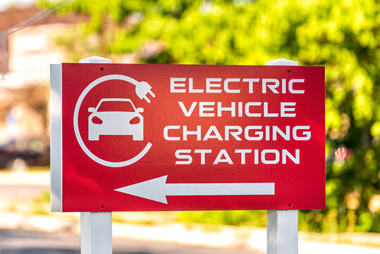 Sign on street for Electric Vehicle Charging station with logo on building in Riverton Commons Plaza in Front Royal, Virginia USA