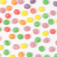 Delicious candy pattern. Sugar candies in red, green, yellow, orange and purple. A modern concept of sweets.