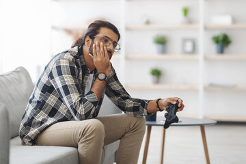 Upset middle-eastern guy got bored while playing video games - Powered by Adobe