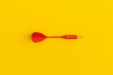 Dart on a yellow background. Top view. Flat lay.