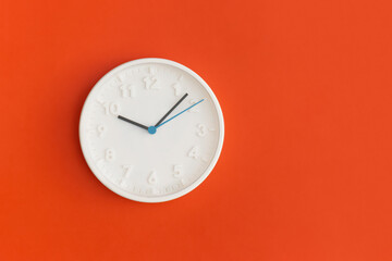 White wall Clock on red background.