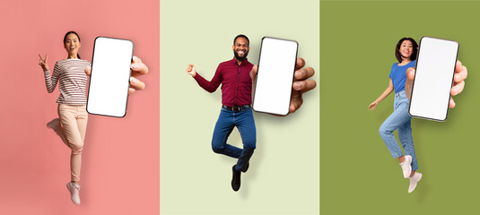 Happy excited asian women and african american man jumping from joy and showing phone with empty...